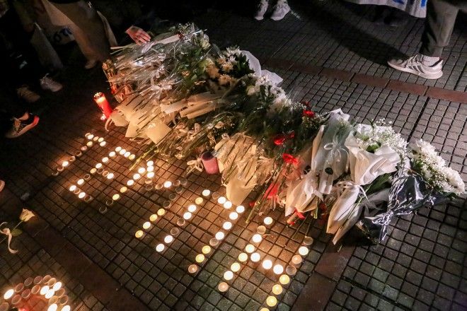 Κόσμος με δάκρυα στα μάτια αφήνει λουλούδια στον σταθμό του ΟΣΕ Λάρισας